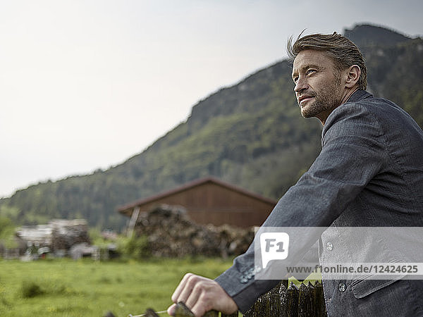 Businessman in rural landscape looking at view