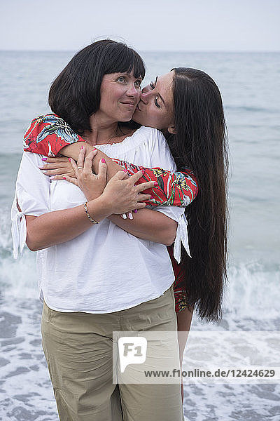 Greece  happy adult daughter kissing her mother in front of the sea