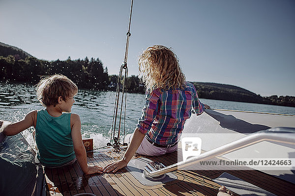 Mother and son sitting on deck of a sailing boat