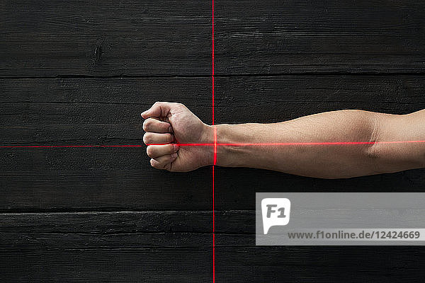 Human hand getting scanned by red light rays