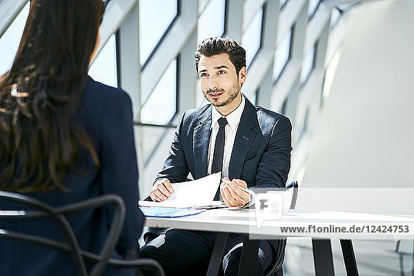 Businessman looking at businesswoman in modern office