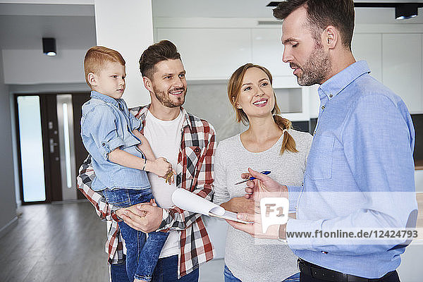 Family and real estate agent talking in new apartment