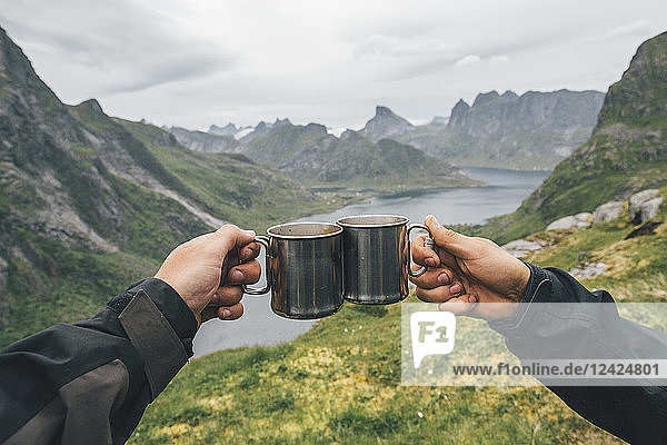 Norway  Lofoten  Moskenesoy  Two people toasting with tin cups