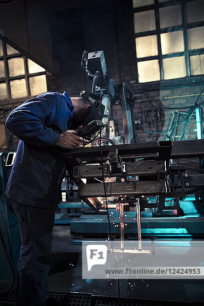 Welder welding metal with robot
