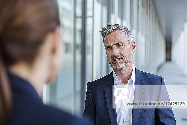 Portrait of sceptical businessman face to face to his business partner