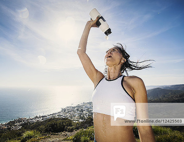 Frau gießt sich Wasser über den Kopf