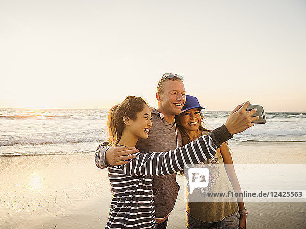 Familie nimmt Selfie am Strand