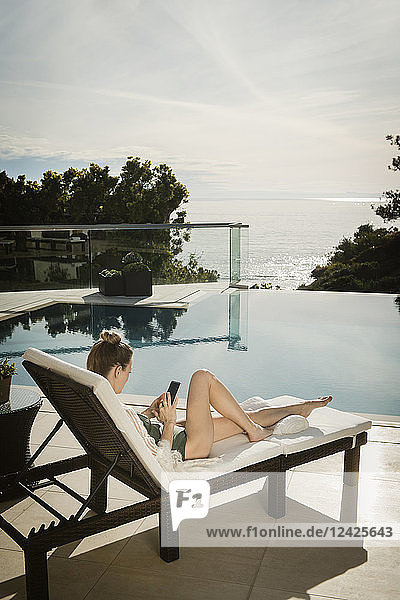 Woman relaxing by swimming pool