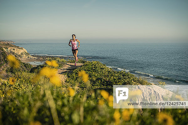 USA  Kalifornien  Newport Beach  Frau läuft entlang Klippe