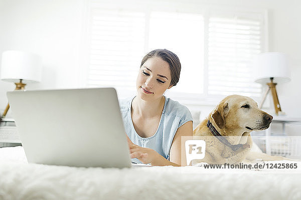 Woman using laptop with dog