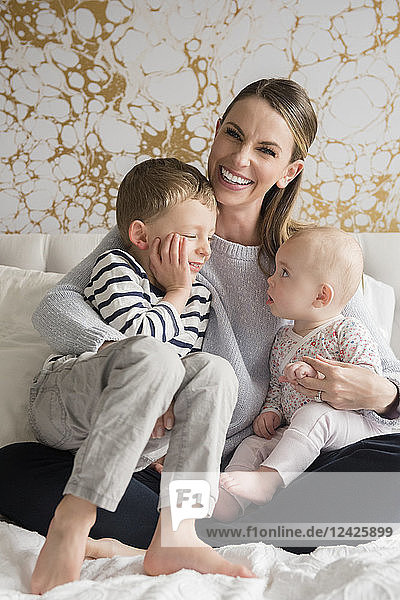 Porträt einer glücklichen Mutter von zwei Kindern (18-23 Monate  4-5)