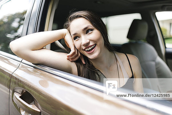 Lächelnde junge Frau im Auto sitzend