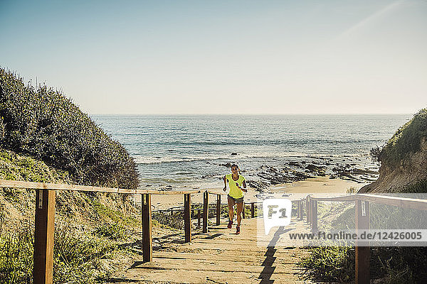 USA  Kalifornien  Newport Beach  Frau läuft Treppe hoch