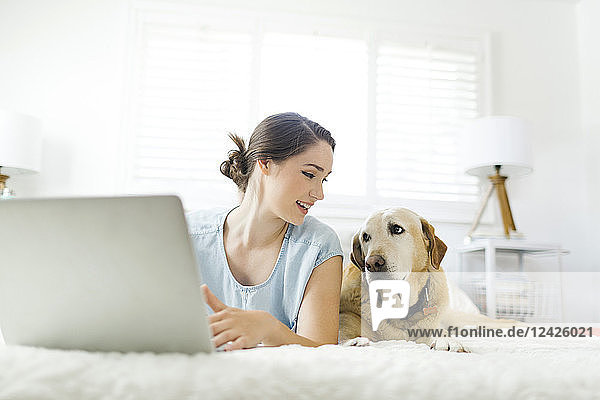 Woman using laptop with dog