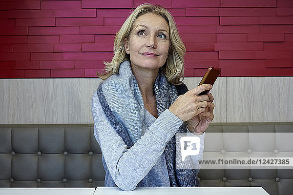 Frau benutzt Smartphone in einem Café