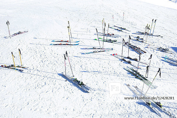 Blick auf viele Skier und Skistöcke im Schnee im Skigebiet im Winter