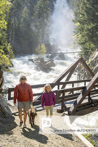 Front view shot of mother  daughter and dog hiking near waterfall  Steamboat Springs  Colorado  USA