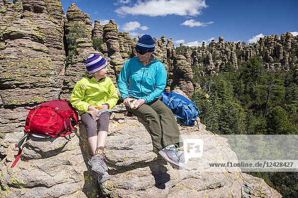 Mutter und Tochter ruhen sich aus und essen beim Wandern im Heart of Rocks  Chiricahua National Monument  Willcox  Arizona  USA