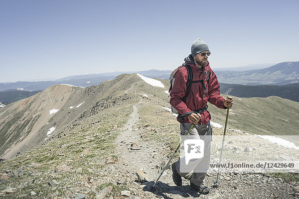 Front view shot of male backpacker hiking on Wheeler Peak highest point in New Mexico Taos New Mexico USA