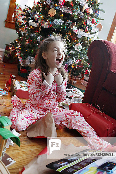 Happy girl after opening Christmas present