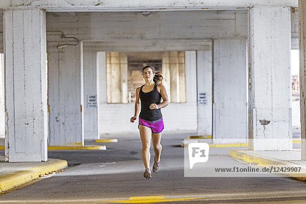 Front view shot of young woman jogging in city  Birmingham  Alabama  USA