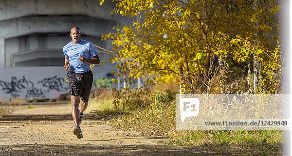 Front view shot of African-American man jogging under bridge  Birmingham  Alabama  USA