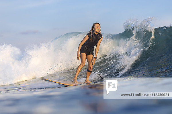 Vorderansicht einer einzelnen Frau  die beim Surfen auf einer Welle reitet