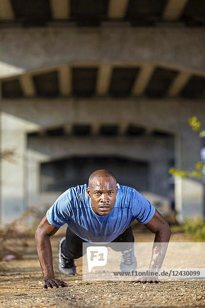 Front view shot of African-American man doing push-ups under bridge  Birmingham  Alabama  USA