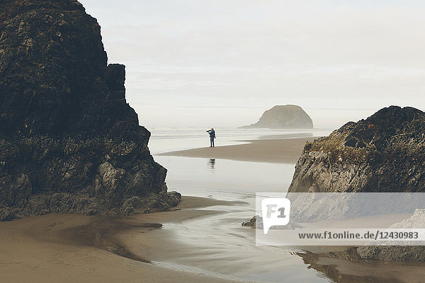 Mann fotografiert bei Ebbe am Strand  Arcadia Beach State Park  Oregon