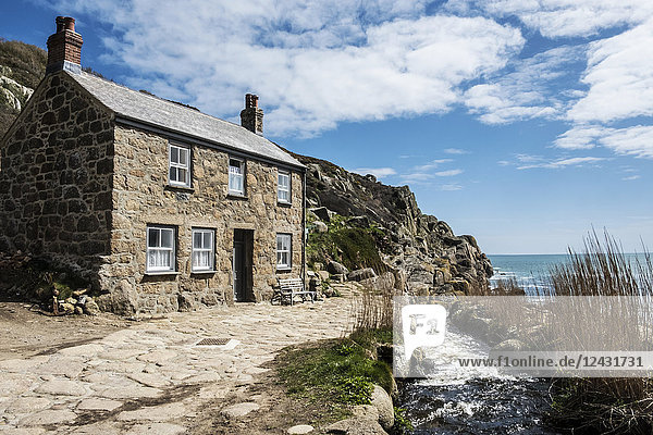 Ein traditionelles Steinhaus an der Küste  mit einem Weg an der Haustür vorbei.