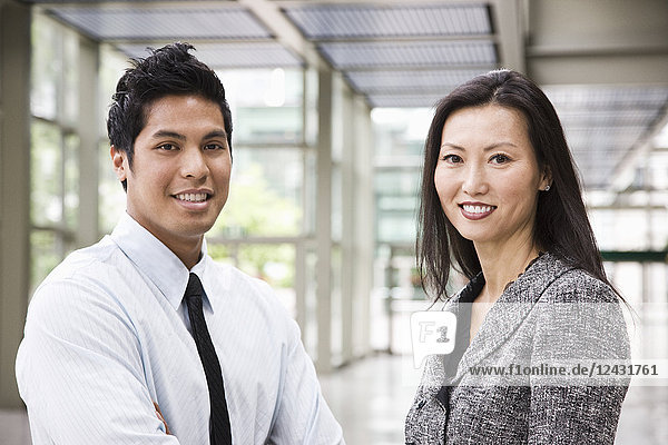 Portrait of an Asian businesswoman and a businessman in the lobby of a convention centre.