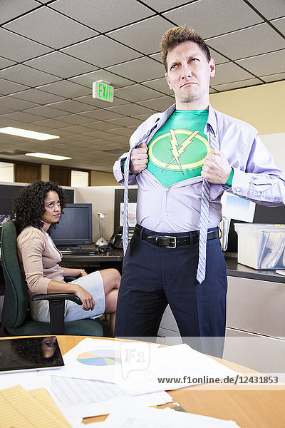 Ein kaukasischer Superheld im Büro eines Mannes macht sich in seinem Büro einsatzbereit.