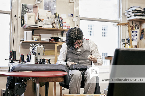 Man sewing suit by hand in family tailor business