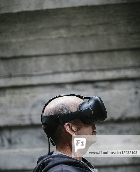 A middle aged man wearing a virtual reality headset.