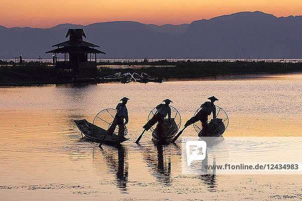 Three fishermen balance on one leg at sunset on Inle Lake  Shan State  Myanmar (Burma)  Asia
