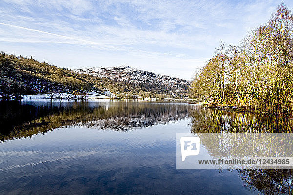A perfect reflection of snow covered mountains and sky in the still waters of Grasmere  Lake District National Park  UNESCO World Heritage Site  Cumbria  England  United Kingdom  Europe