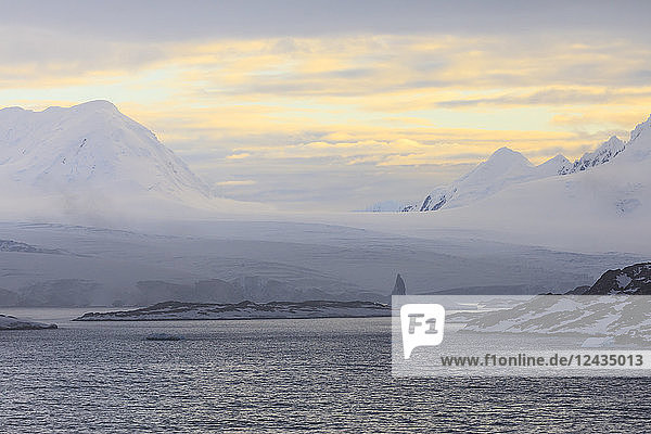 Sonnenaufgang über nebligen Bergen  Gezeitengletschern und Eisbergen  Anvers Island  Antarktische Halbinsel  Antarktis  Polarregionen