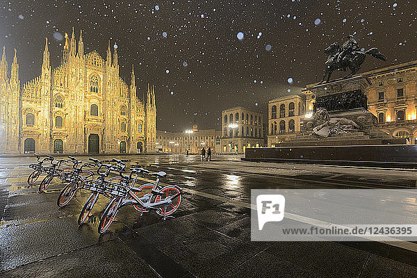 Abgestellte Fahrräder auf der Piazza Duomo während eines nächtlichen Schneefalls  Mailand  Lombardei  Norditalien  Italien  Europa