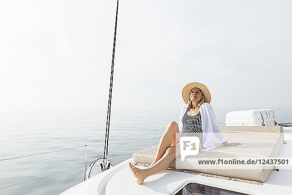Mature woman relaxing on a catamaran  taking a sunbath