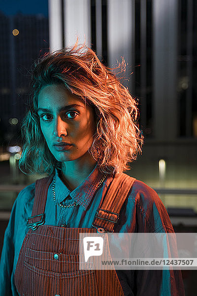 Portrait of a beautiful woman at night  wearing dungarees