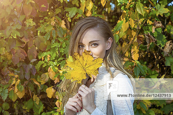 Portrait of woman with yellow autumn leaf