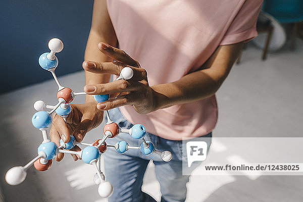 Female scientist holding molecule model