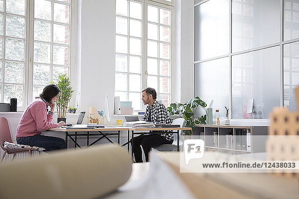 Colleagues working at desk in a loft office
