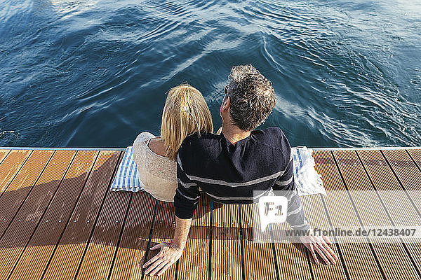 Mature couple sitting on jetty  relaxing at the sea