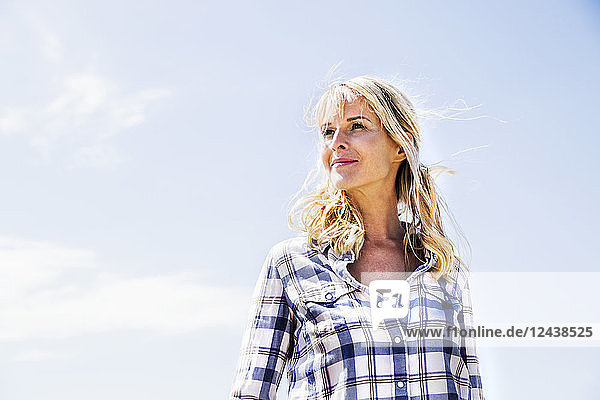 Blond woman wearing checked shirt outdoors