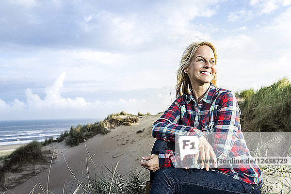 Smiling woman sitting in dunes