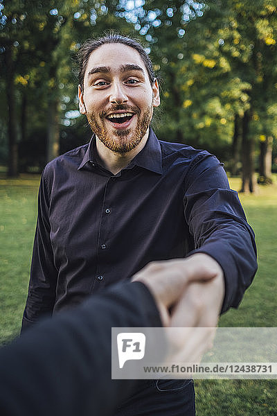 Young businessman greeting business partner in a park  negotiating business transactions