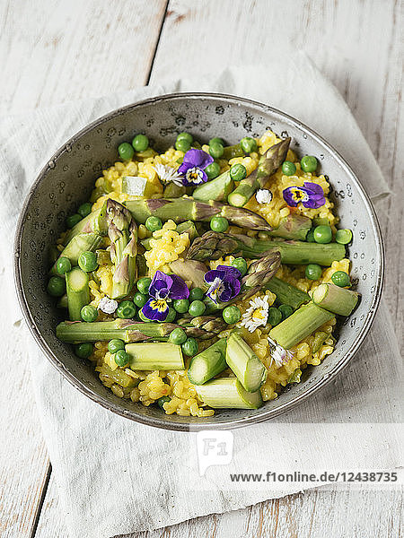 Risotto with green asparagus and peas  garnished with edible flowers
