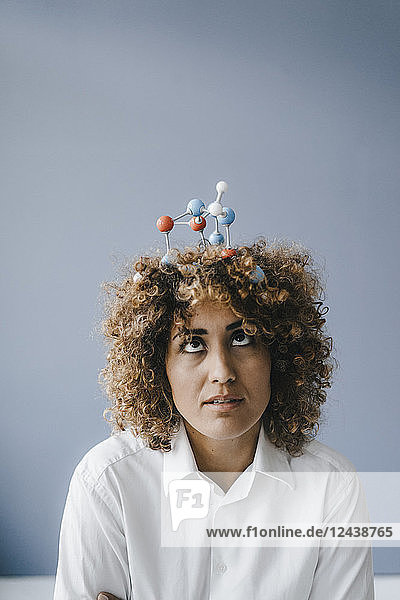 Young woman with molecule model in her hair