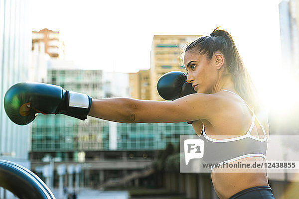 Sportive young woman boxing in the city